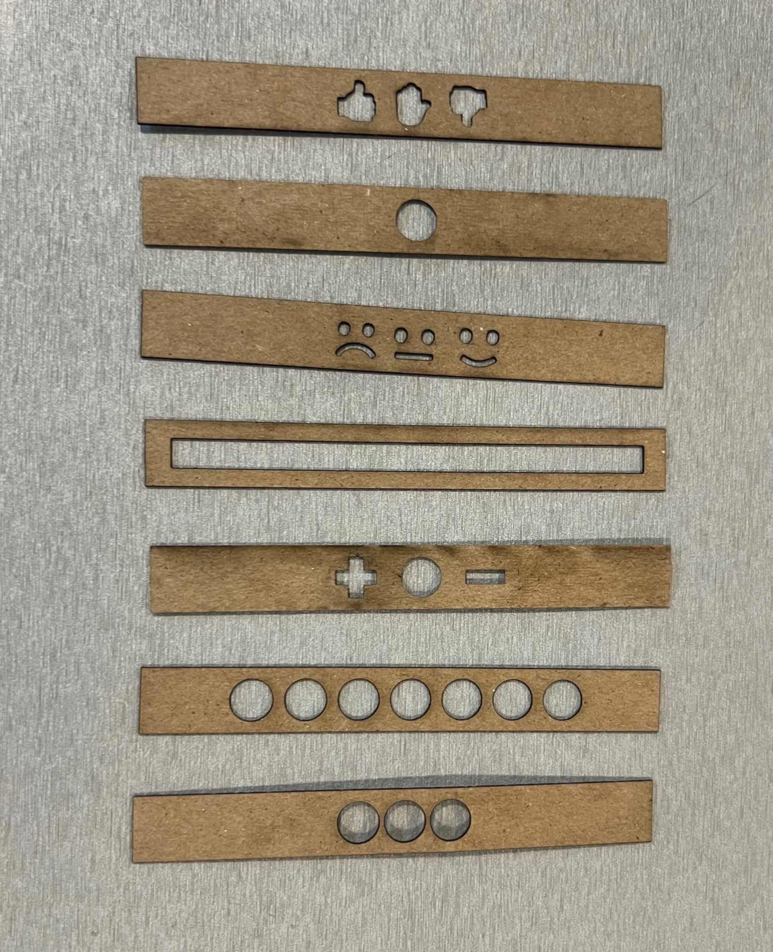 Laser-cut prototypes testing different smiley-face and symbol light patterns
